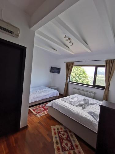 a bedroom with two beds and a window at Belvedere Resort Moieciu in Moieciu de Jos