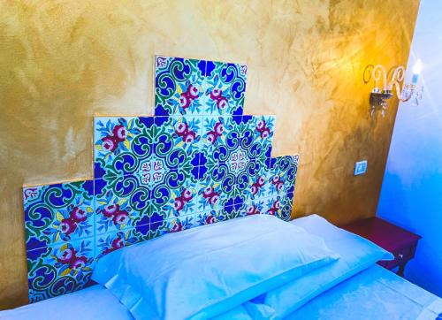 a bedroom with a bed with a blue head board at Araba Fenice Hotel in San Vito lo Capo