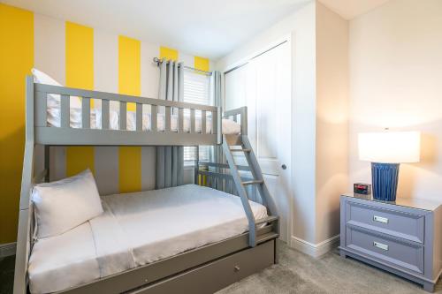 Dormitorio pequeño con litera y lámpara en Alluring Home with Private Pool by Rentyl Near Disney with Resort Amenities - 280S, en Loughman