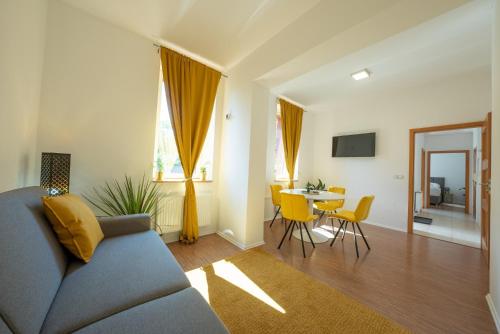 a living room with a blue couch and a table at Národní dům Podbořany in Podbořany