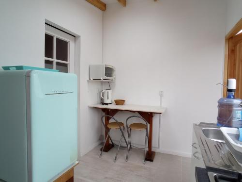 a small kitchen with a table and a refrigerator at Loft Tongoy 3 Peninsula in Coquimbo