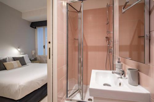 a bathroom with a shower and a sink and a bed at Hotel Casa Petrarca in Venice