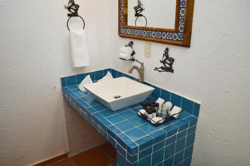 La salle de bains est pourvue d'un comptoir en carrelage bleu et d'un lavabo. dans l'établissement La Casona Pirámides, à San Martín de las Pirámides