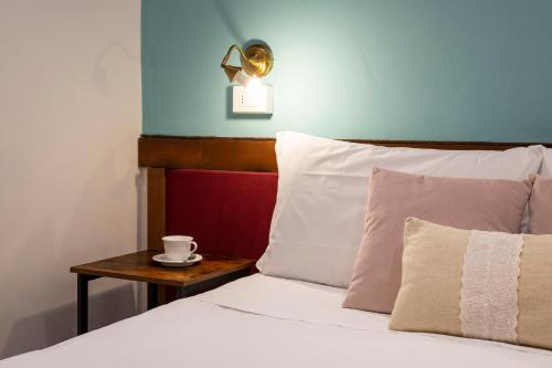 a bed with a table with a cup on it at Hotel Casa Petrarca in Venice