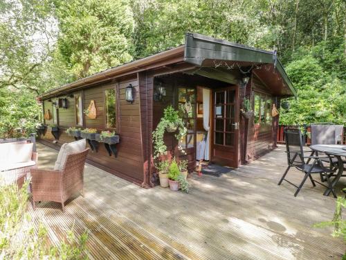 a cabin with a deck with a table and chairs at Scafell Lodge in Windermere