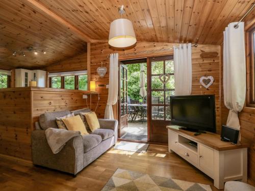 a living room with a couch and a television at Scafell Lodge in Windermere