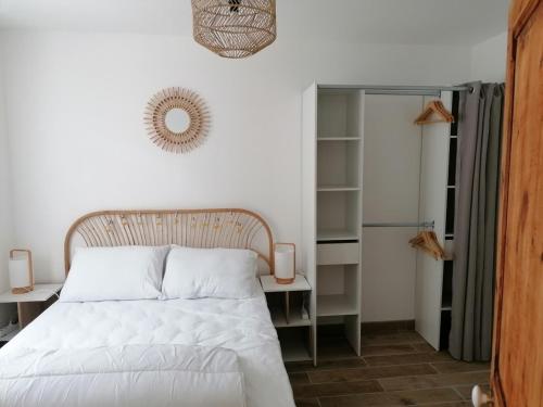 1 dormitorio con cama blanca y espejo en Gîte chez Louisette en Le Crotoy