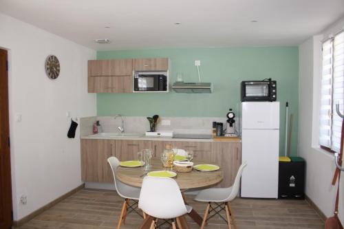 een keuken met een tafel en stoelen en een koelkast bij Gîte chez Louisette in Le Crotoy