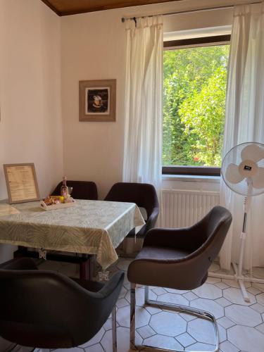 ein Esszimmer mit einem Tisch, Stühlen und einem Fenster in der Unterkunft Ferienhaus Seeröschen - Gesamte Unterkunft in Pörtschach am Wörthersee