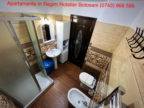 a bathroom with two sinks and a glass shower at Apartament frumos cu 3 camere situat la partier in Botoşani