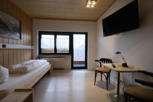 a bedroom with a bed and a desk and a table at Pension Hofmann in Oberasbach