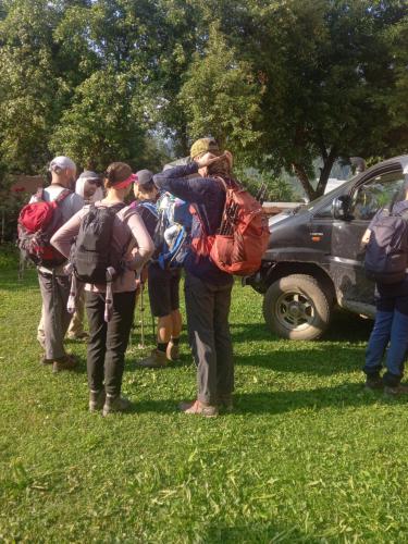 a group of people standing in the grass with backpacks at Lia Jamdeliani Guest House in Mazeri