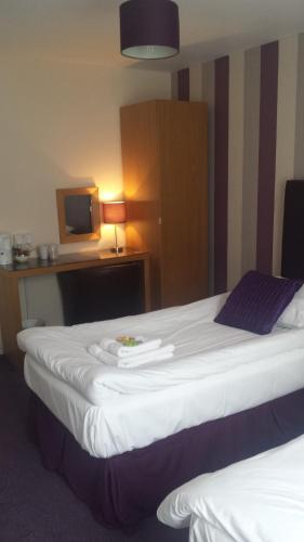 a hotel room with two beds and a tv at Duke of Buckingham in Portsmouth