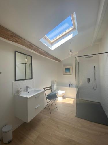 a bathroom with a sink and a toilet and a skylight at La Belle Parenthèse in Vergné