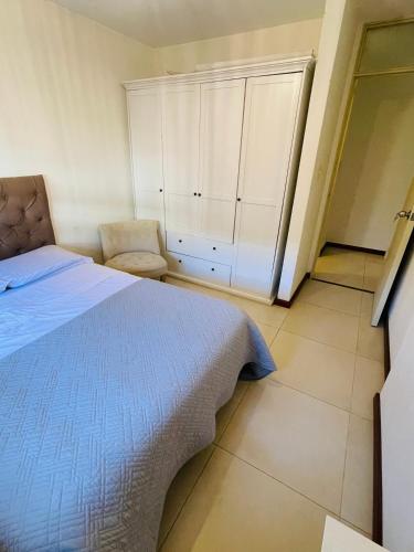 een slaapkamer met een bed en een stoel bij Edificio Baalbek I in Montevideo