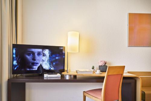 a television sitting on a desk in a hotel room at Living Place Hotel in Villanova