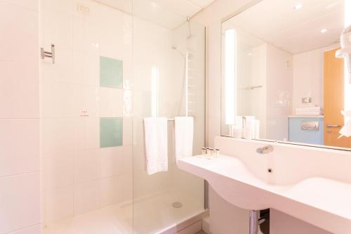 a white bathroom with a sink and a shower at Living Place Hotel in Villanova