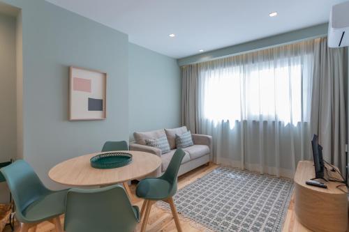Una sala de estar con un sofá, una mesa y sillas. en Ajuda Luxury Appartments, en Lisboa