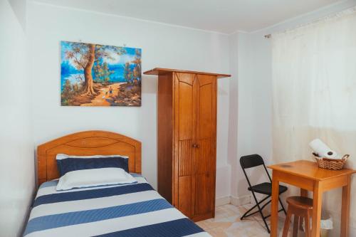 a bedroom with a bed and a table and a desk at Villa Loretana in Yurimaguas