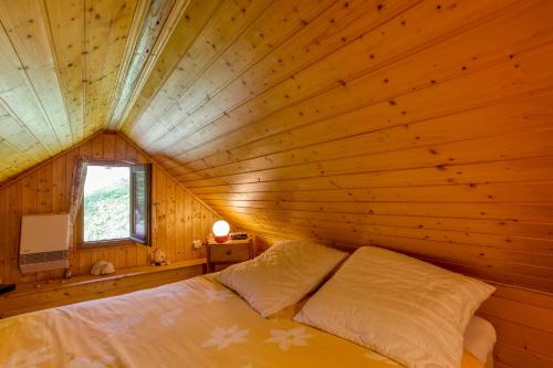 1 dormitorio con 1 cama en una habitación de madera en Chalet Lo Grané en Jarrier