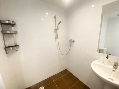 une salle de bain blanche avec une douche et un lavabo dans l'établissement Villa Madeleine - Résidence Services Seniors, à Nice