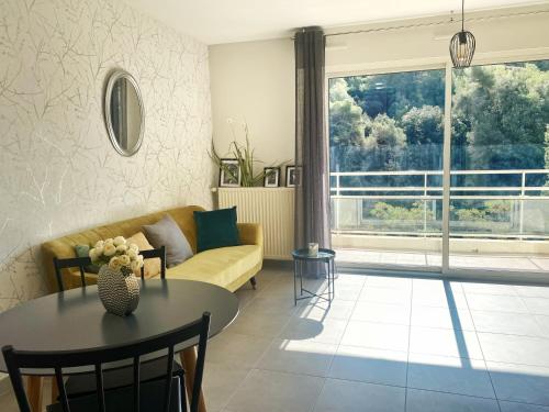 uma sala de estar com um sofá e uma mesa em Villa Madeleine - Résidence Services Seniors em Nice