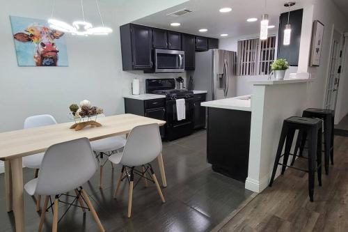 a kitchen with a wooden table and white chairs at L - Fully remodeled and professionally decorated in Las Vegas