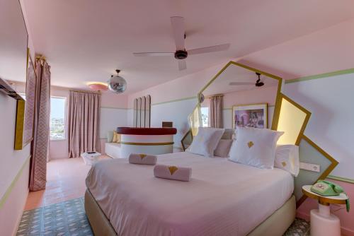 a bedroom with a large white bed in a room at Grand Paradiso Ibiza - Adults Only in San Antonio Bay