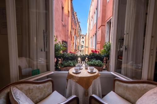 a room with a table and two chairs and a window at Hotel Casa Petrarca in Venice