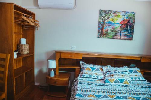 - une chambre avec un lit et une photo sur le mur dans l'établissement Hospedaje Garcilazo, à Yurimaguas