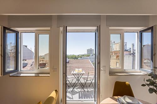 a room with three windows and a view of a city at Urban House by LovelyStay in Porto