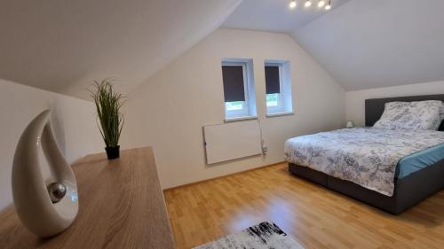 een slaapkamer met een bed en een houten vloer bij Ferienhaus Ranzer in Spielberg