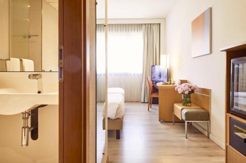 a hotel room with a bed and a bathroom at Living Place Hotel in Villanova