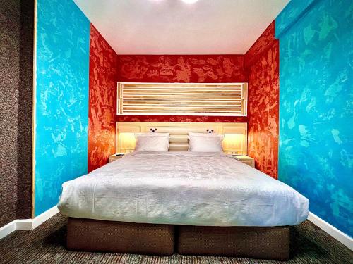 a bedroom with a large bed with red walls at Kavsadze street apartment in Tbilisi City