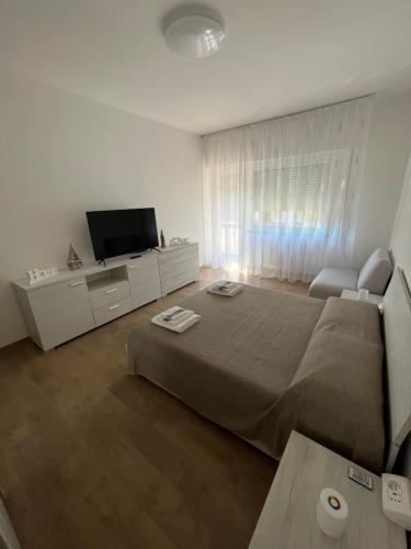 a bedroom with a bed and a flat screen tv at La casa di Maria in Rapallo