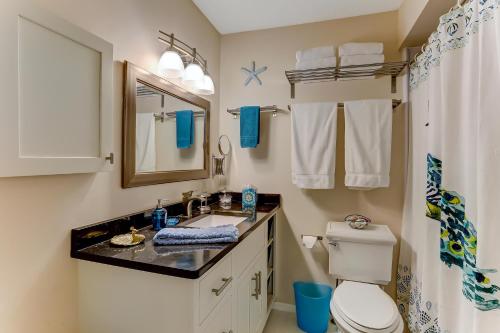 a bathroom with a sink and a toilet and a mirror at Walk to Beach-Forest Ridge 2747-Pool,Tennis,Pickleball,Playground-Nestled Amongst the Oaks in Fernandina Beach