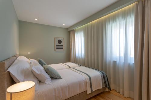 a bedroom with a bed and a large window at Ajuda Luxury Appartments in Lisbon