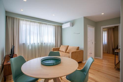ein Wohnzimmer mit einem Tisch, Stühlen und einem Sofa in der Unterkunft Ajuda Luxury Appartments in Lissabon