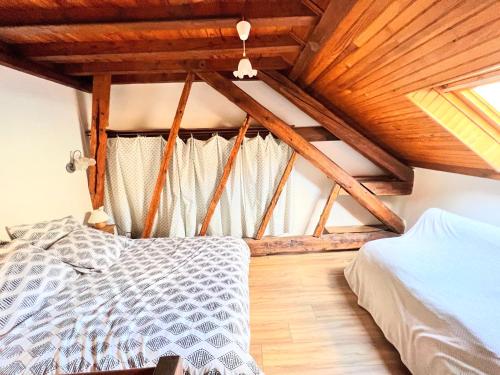 um quarto com uma cama e um tecto de madeira em T2 au charme authentique em Briançon
