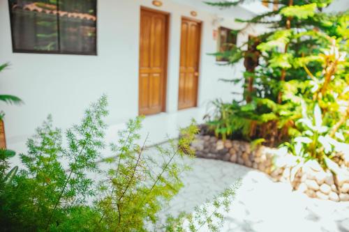 a white house with a door and some plants at Villa Loretana in Yurimaguas
