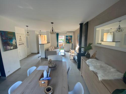 een woonkamer met een bank en een tafel en stoelen bij Maison avec piscine, climatisée, proche plage in Roquebrune-sur-Argens
