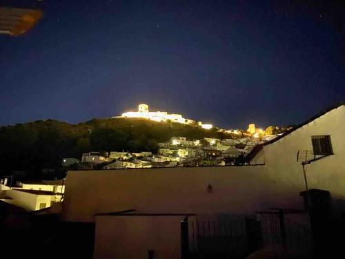 a lit up building on top of a hill at night at La casa del piano - Beautiful 18th century house with courtyard & pool in Jimena de la Frontera
