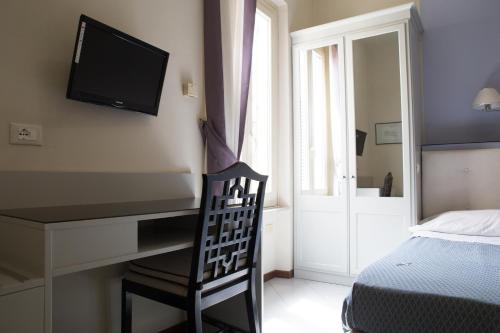 a bedroom with a desk and a bed and a television at Hotel Brasile in Montecatini Terme