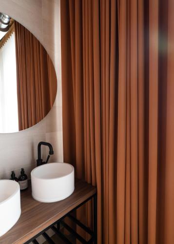 a bathroom with two sinks and a mirror at Cousins Boutique Hotel in Maastricht