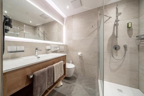 a bathroom with a shower and a sink and a toilet at Pension Bergfrieden in Obergurgl