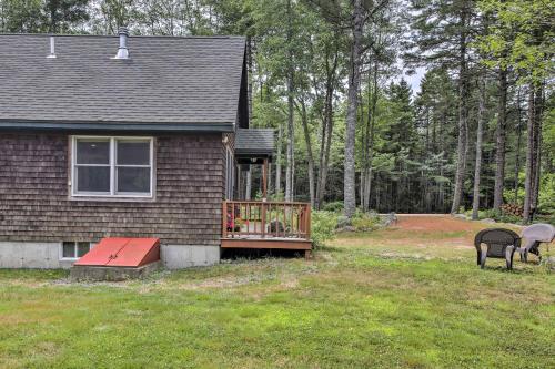 a house with a porch and a dog on a deck at Hidden Gem Cottage Near Blue Hill Peninsula in Brooklin