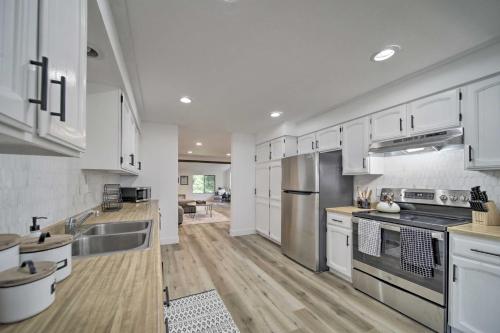 a kitchen with white cabinets and stainless steel appliances at Bright and Airy Liberty Lake Abode with Backyard! in Liberty Lake
