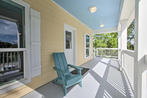 a blue rocking chair sits on the front porch of a house at Modern Waveland Home with Deck, Walk to Beach! in Waveland