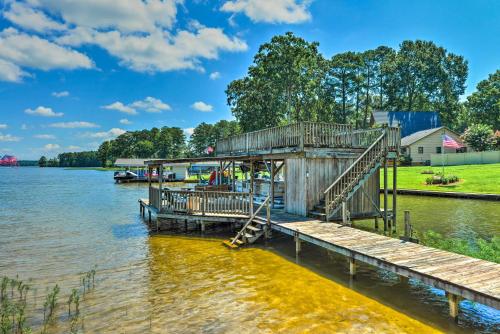 a dock on a lake with a house at Beautiful Lakefront Retreat with Dock and Grill! in Littleton