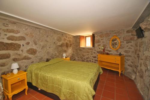 um quarto com uma cama verde e duas mesas de cabeceira em Cabaninhas House em Terras de Bouro